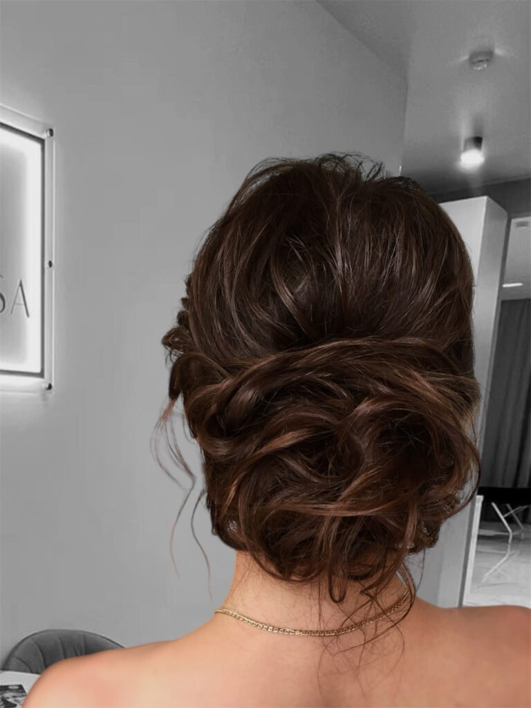 Romantic low bun event hairstyle with soft curls and elegant volume in Chicago