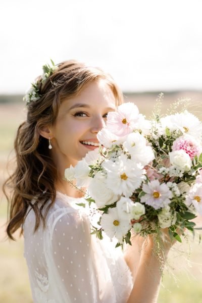 Boho chic bridal makeup and hairstyle with flowers in hair and natural waves by ABC Face in Chicago