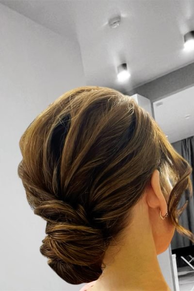 Elegant twisted low updo hairstyle with soft volume for weddings and evening events in Chicago