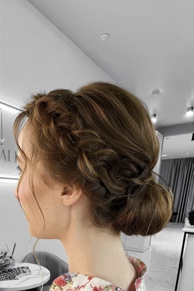 Braided low bun event hairstyle with soft texture and romantic elegance in Chicago